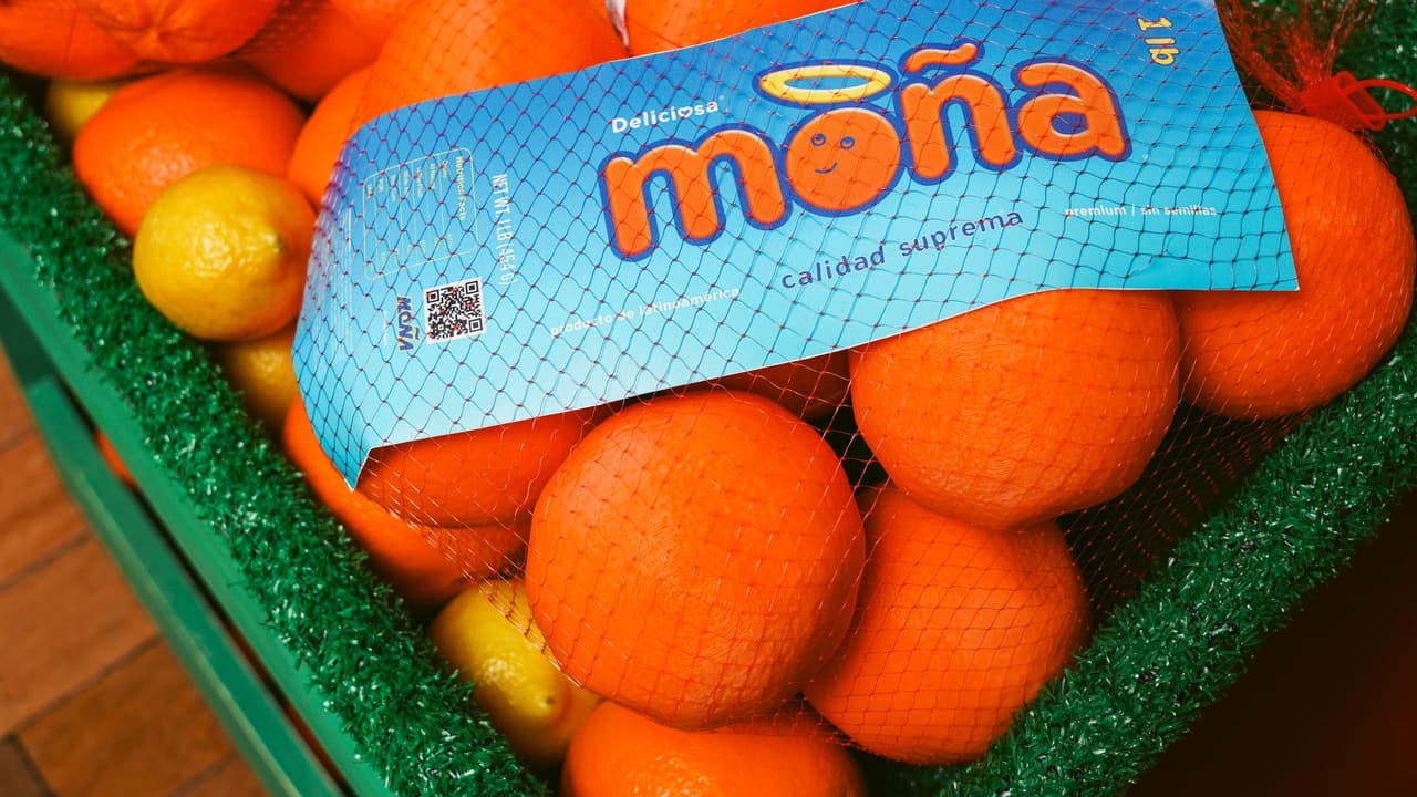 Astroturf crate of oranges and lemons with two blue MOÑA net-bag labels at the event kiosk